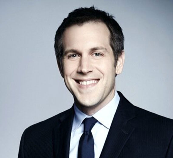 Jordy Jones posa con su computadora portátil y su hijo en su regazo.